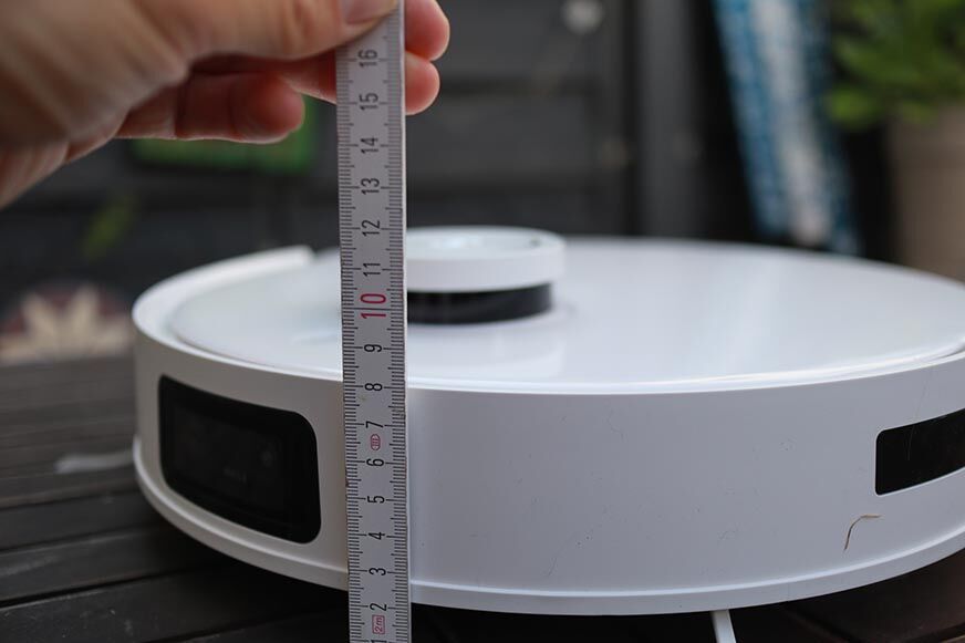 Die Höhe des Ecovacs Deebot T10 wird mit einem Lineal ausgemessen.